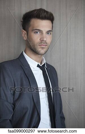 Young businessman leaning against wall, portrait View Large Photo Image Stock Photo - Young businessman leaning against wall, portrait. Fotosearch