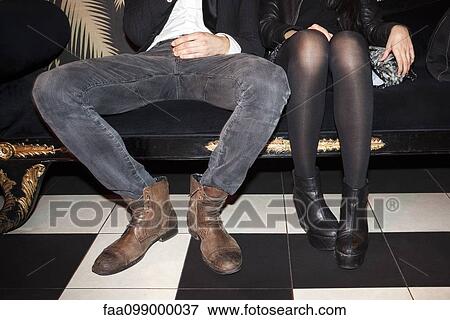 Stock Photo - Young couple sitting side by side at night club. Fotosearch