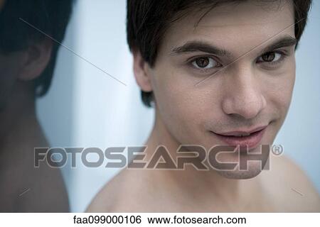 Stock Photograph - Young man with bare shoulders, smiling, portrait. Fotosearch