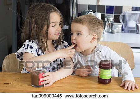 Young siblings tasting contents of jars with their fingers View Large Photo Image Stock Photography - Young siblings tasting contents of jars with their fingers. Fotosearch