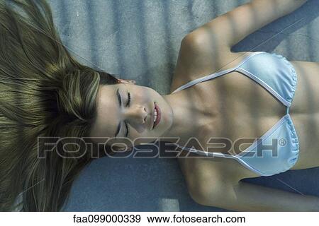 Young woman in bikini lying in shade, eyes closed View Large Photo Image Stock Photo - Young woman in bikini lying in shade, eyes closed. Fotosearch