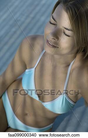 Young woman relaxing in bikini with eyes closed View Large Photo Image Stock Image - Young woman relaxing in bikini with eyes closed. Fotosearch