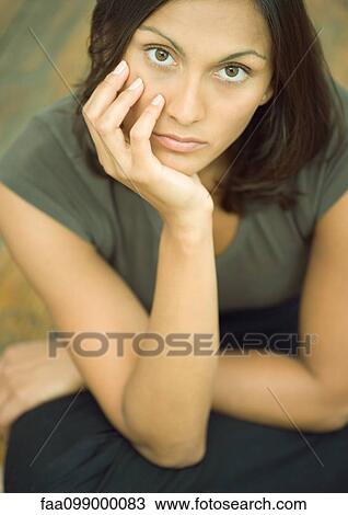 Young woman with hand under chin, portrait View Large Photo Image Stock Image - Young woman with hand under chin, portrait. Fotosearch