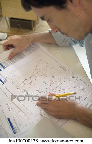 Architect examining blueprint View Large Photo Image Stock Photograph - Architect examining blueprint. Fotosearch