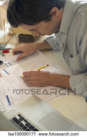 Stock Photo - Architect working on blueprint. Fotosearch