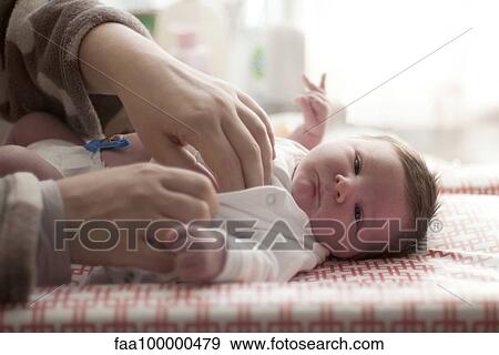 Baby being dressed by parent, cropped View Large Photo Image Stock Photo - Baby being dressed by parent, cropped. Fotosearch