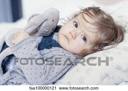 Baby girl lying down with stuffed toy, portrait View Large Photo Image Stock Image - Baby girl lying down with stuffed toy, portrait. Fotosearch