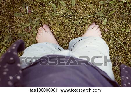 Stock Image - Baby walking on grass, cropped personal perspective. Fotosearch