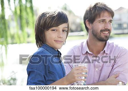 Boy relaxing outdoors with his family View Large Photo Image Picture - Boy relaxing outdoors with his family. Fotosearch