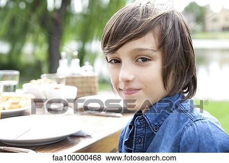 Stock Photo - Boy smiling outdoors, portrait. Fotosearch