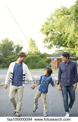 Boy walking with his fathers outdoors View Large Photo Image Picture - Boy walking with his fathers outdoors. Fotosearch
