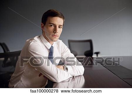 Businessman sitting at conference table, portrait View Large Photo Image Stock Photo - Businessman sitting at conference table, portrait. Fotosearch