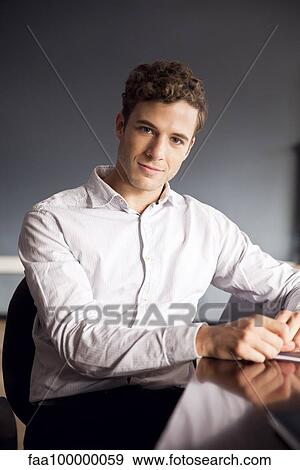 Businessman sitting at desk, portrait View Large Photo Image Stock Photo - Businessman sitting at desk, portrait. Fotosearch