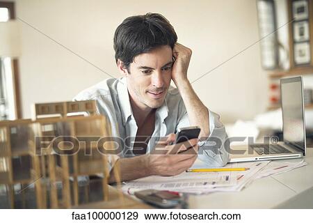 Businessman using cell phone at desk View Large Photo Image Stock Photo - Businessman using cell phone at desk. Fotosearch