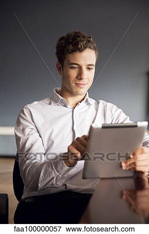 Businessman using digital tablet in office View Large Photo Image Stock Photo - Businessman using digital tablet in office. Fotosearch