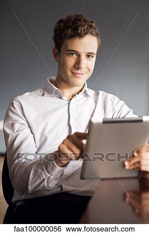 Stock Photograph - Businessman using digital tablet in office. Fotosearch