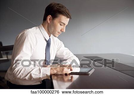 Businessman using digital tablet in office View Large Photo Image Stock Photograph - Businessman using digital tablet in office. Fotosearch