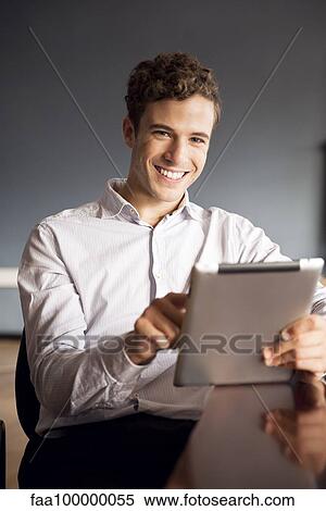 Stock Photography - Businessman using digital tablet in office. Fotosearch