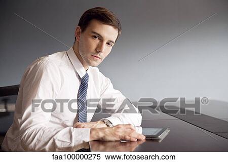 Businessman using digital tablet in office View Large Photo Image Stock Photography - Businessman using digital tablet in office. Fotosearch