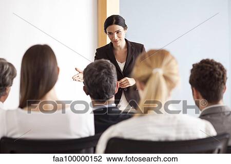 Stock Image - Businesswoman facilitating group discussion. Fotosearch