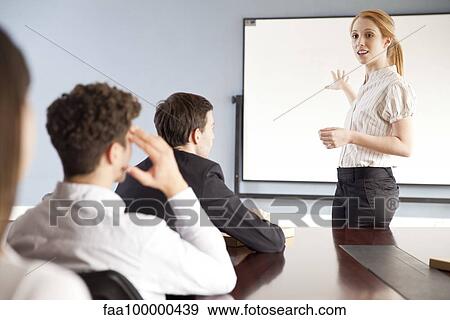 Stock Photo - Businesswoman giving presentation at corporate meeting. Fotosearch