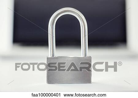 Stock Image - Close-up of padlock with laptop computer in background. Fotosearch