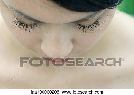 Stock Photograph - Close-up of young woman's face, eyes closed. Fotosearch