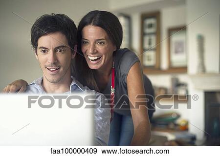 Couple looking at laptop computer together View Large Photo Image Stock Photo - Couple looking at laptop computer together. Fotosearch