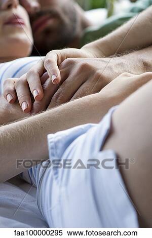 Couple reclining together, holding hands View Large Photo Image Stock Photography - Couple reclining together, holding hands. Fotosearch