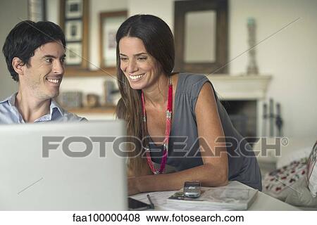 Couple using laptop computer at home View Large Photo Image Stock Photo - Couple using laptop computer at home. Fotosearch