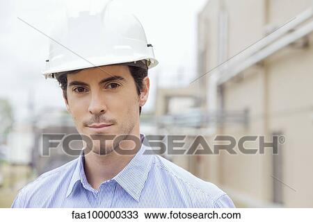 Stock Image - Engineer at industrial site, portrait. Fotosearch