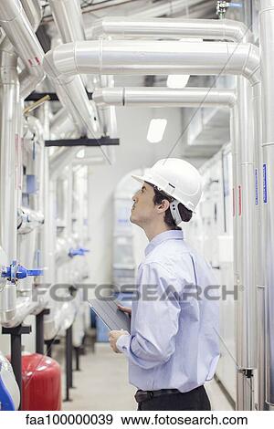 Engineer checking equipment in operation at industrial plant View Large Photo Image Stock Photo - Engineer checking equipment in operation at industrial plant. Fotosearch