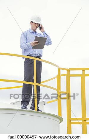 Stock Photo - Engineer conducting safety inspection at industrial plant. Fotosearch
