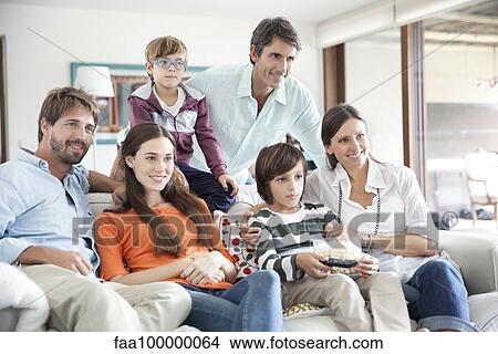 Picture - Extended family watching TV together. Fotosearch