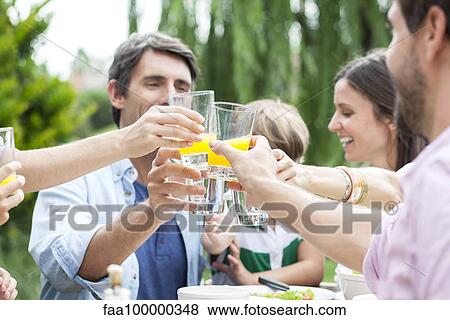 Family clinking glasses at outdoor gathering View Large Photo Image Stock Photo - Family clinking glasses at outdoor gathering. Fotosearch