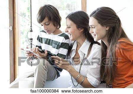 Picture - Family enjoying digital tablet together. Fotosearch