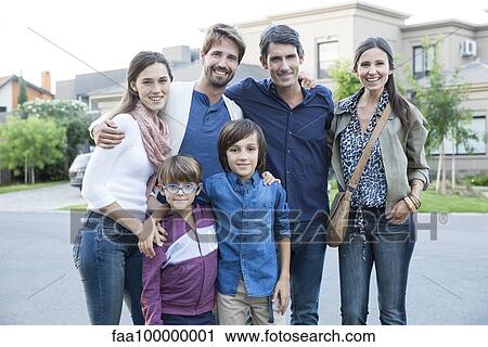 Stock Image - Family posing together on suburban street, portrait. Fotosearch