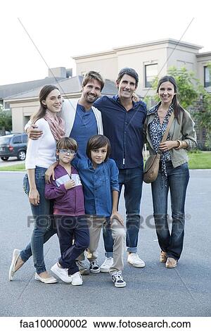 Stock Image - Family posing together on suburban street, portrait. Fotosearch