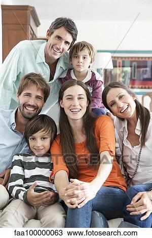 Stock Image - Family together in living room, portrait. Fotosearch