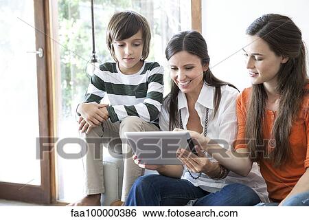 Family using digital tablet together View Large Photo Image Stock Photograph - Family using digital tablet together. Fotosearch