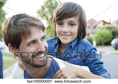 Stock Photo - Father and son together outdoors, portrait. Fotosearch