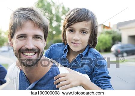 Stock Photo - Father and son together outdoors, portrait. Fotosearch