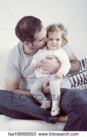 Father holding baby girl on lap, kissing her cheek View Large Photo Image Stock Image - Father holding baby girl on lap, kissing her cheek. Fotosearch