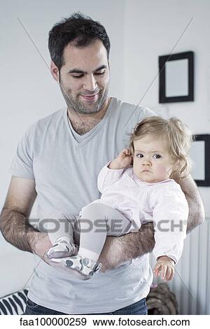 Stock Photo - Father holding baby girl. Fotosearch