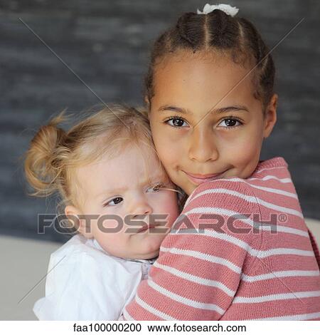 Girl embracing baby girl, portrait View Large Photo Image Stock Image - Girl embracing baby girl, portrait. Fotosearch