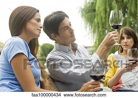 Picture - Man explaining wine complexity to friends. Fotosearch
