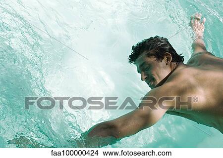 Man leaning over pool, arms in water View Large Photo Image Picture - Man leaning over pool, arms in water. Fotosearch