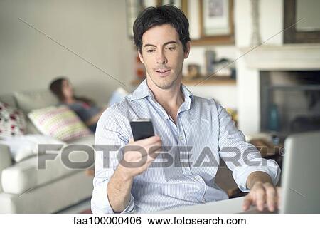 Man looking at cell phone View Large Photo Image Stock Photograph - Man looking at cell phone. Fotosearch