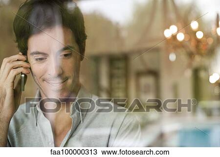 Man using cell phone at home View Large Photo Image Stock Image - Man using cell phone at home. Fotosearch