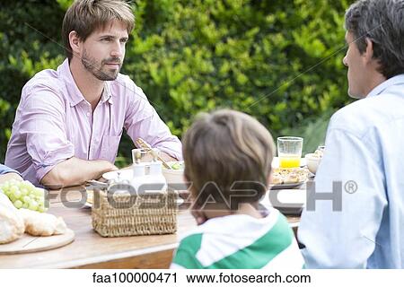 Men chatting at outdoor family gathering View Large Photo Image Stock Image - Men chatting at outdoor family gathering. Fotosearch